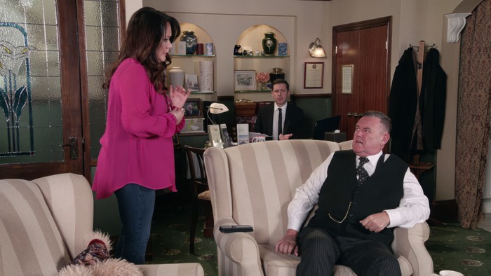 Christina stands over George in the undertakers as Todd watches on in a. scene from Coronation Street