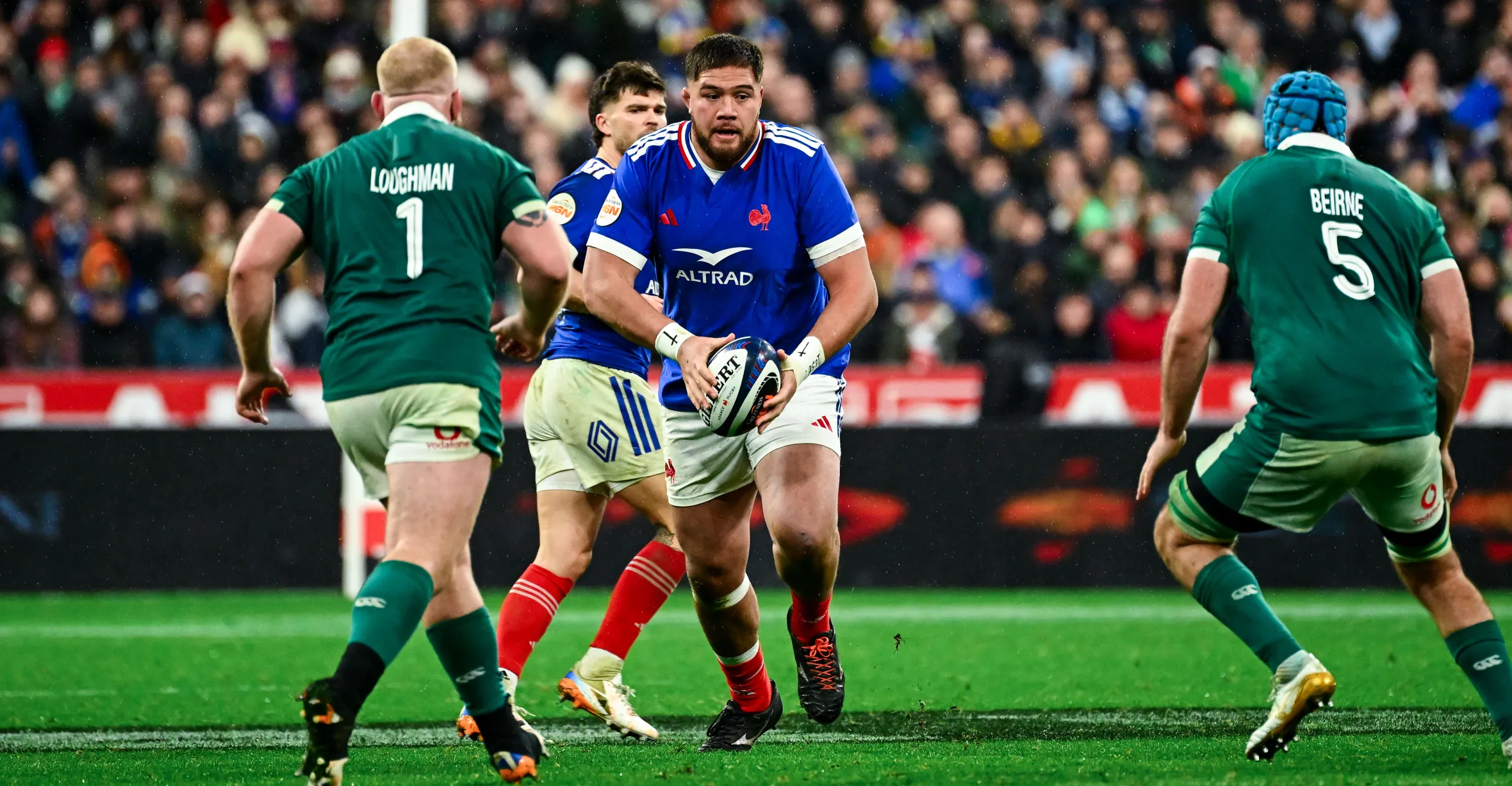 Emmanuel Meafou of France holding the rugby ball, surrounded by two Ireland players, Loughman and Beirne, during the Six Nations match.