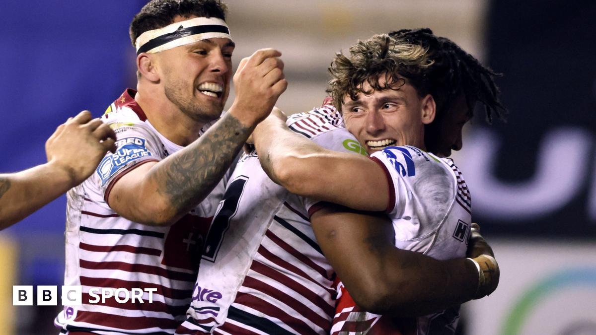 Noah Hodkinson (right, in Wigan's red-and-white kit) is hugged by Junior Nsemba after scoring a try, with two another team-mates joining the celebration