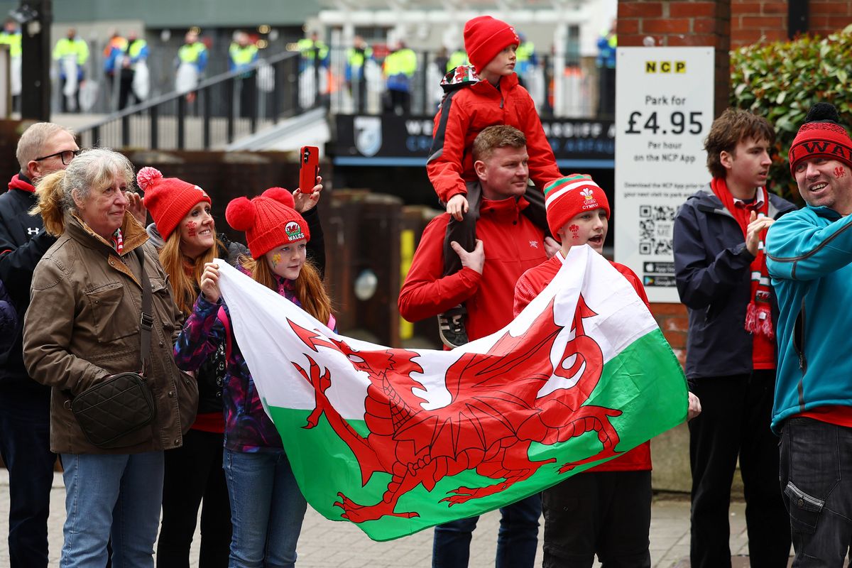 Rugby fans holding a Welsh flag