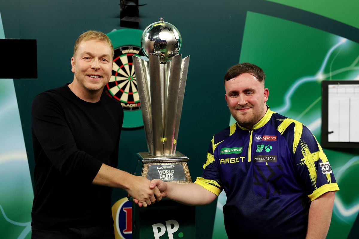 LONDON, ENGLAND - JANUARY 03: Luke Littler of England is presented with the Sid Waddell trophy by Former British Olympic Cyclist Sir Chris Hoy after defeating Gian van Veen of the Netherlands (not pictured) during the 2025/26 Paddy Power World Darts Championship Final match between Luke Littler and Gian van Veen at Alexandra Palace on January 03, 2026 in London, England. (Photo by Warren Little/Getty Images)