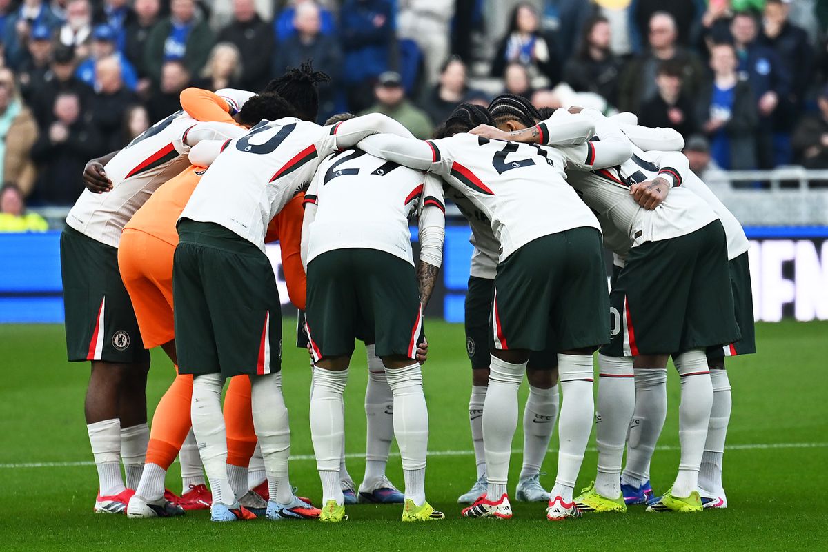 Chelsea players huddle before a game against Everton