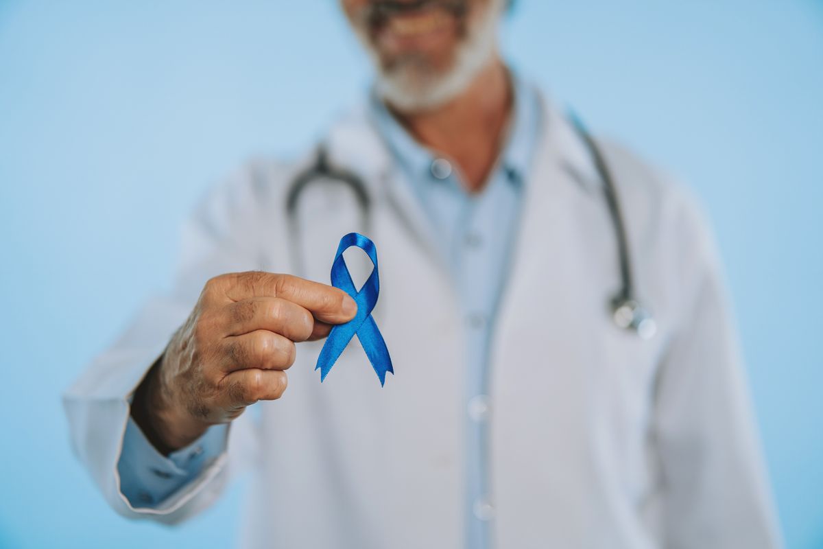 Doctor holding a cancer awareness pin