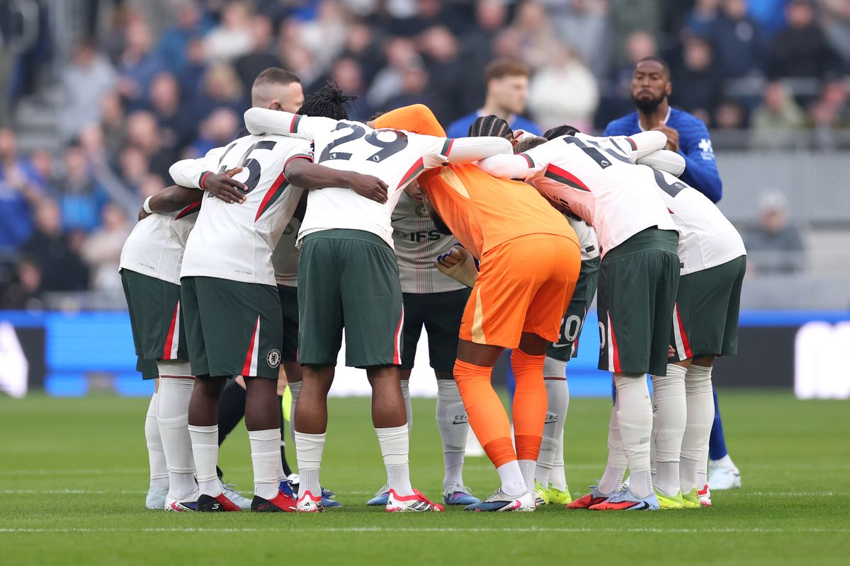 Chelsea players huddle before a game against Everton
