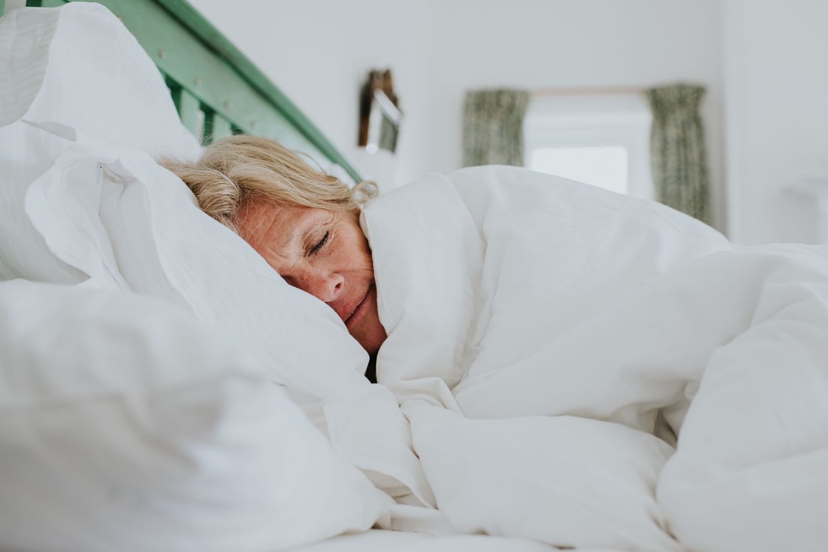 A woman in bed under a duvet
