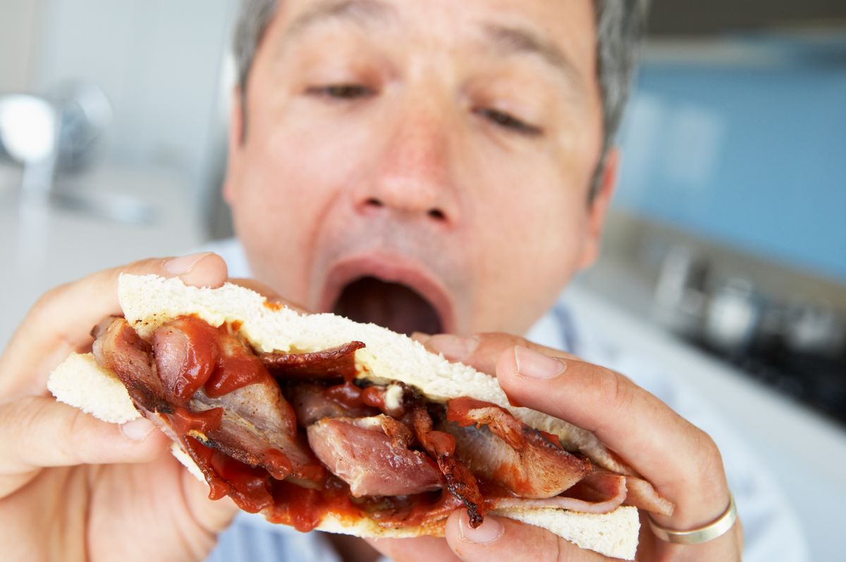 Man eating bacon sandwich