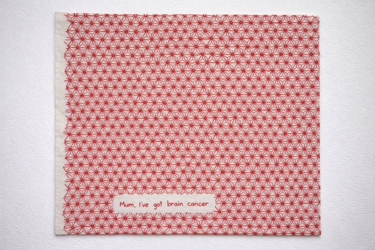 A canvas with red stitching. A message stitched into the canvas reads 'mum, I've got brain cancer'