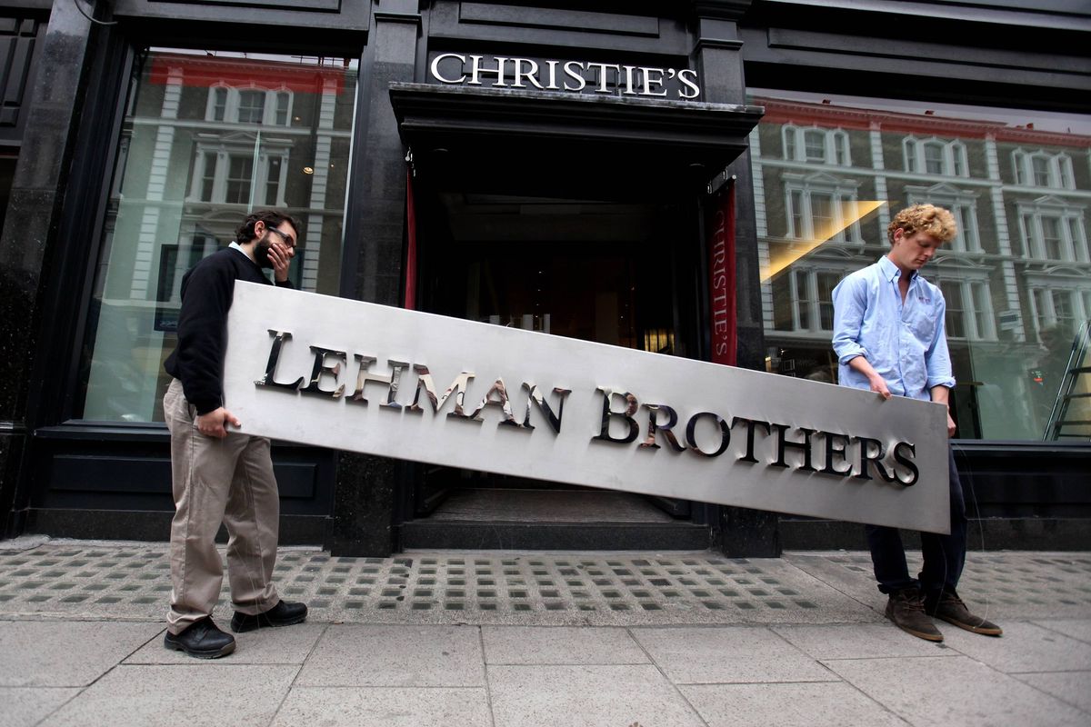 LONDON, ENGLAND - SEPTEMBER 24:  Two employees of Christie's auction house manoeuvre the Lehman Brothers corporate logo, which is estimated to sell for 3000 GBP and is featured in the sale of art owned by the collapsed investment bank Lehman Brothers on September 24, 2010 in London, England. The "Lehman Brothers: Artwork and Ephemera" sale will take place on September 29, 2010, on the second anniversary of the firm's bankruptcy, and comprises of artworks which hung on the walls of Lehman Brothers' offices in Europe.  (Photo by Oli Scarff/Getty Images)
