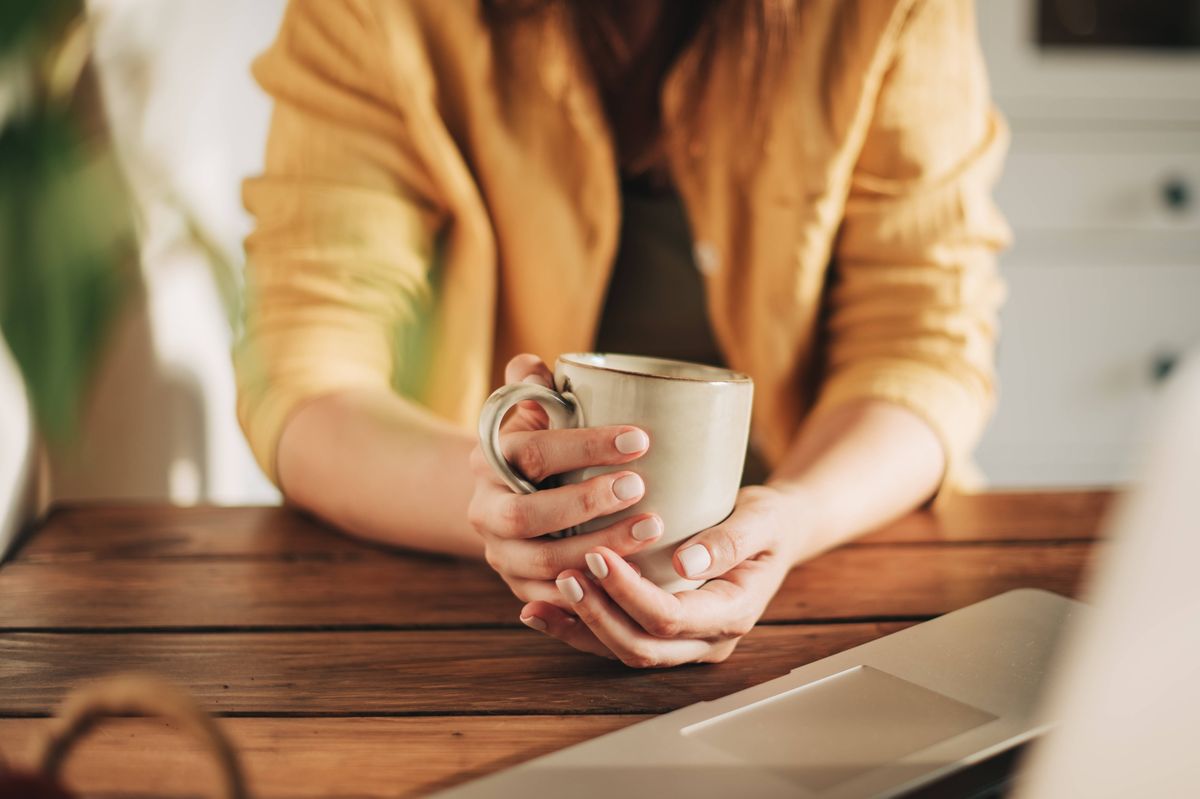 Woman drinking cup of tea generic