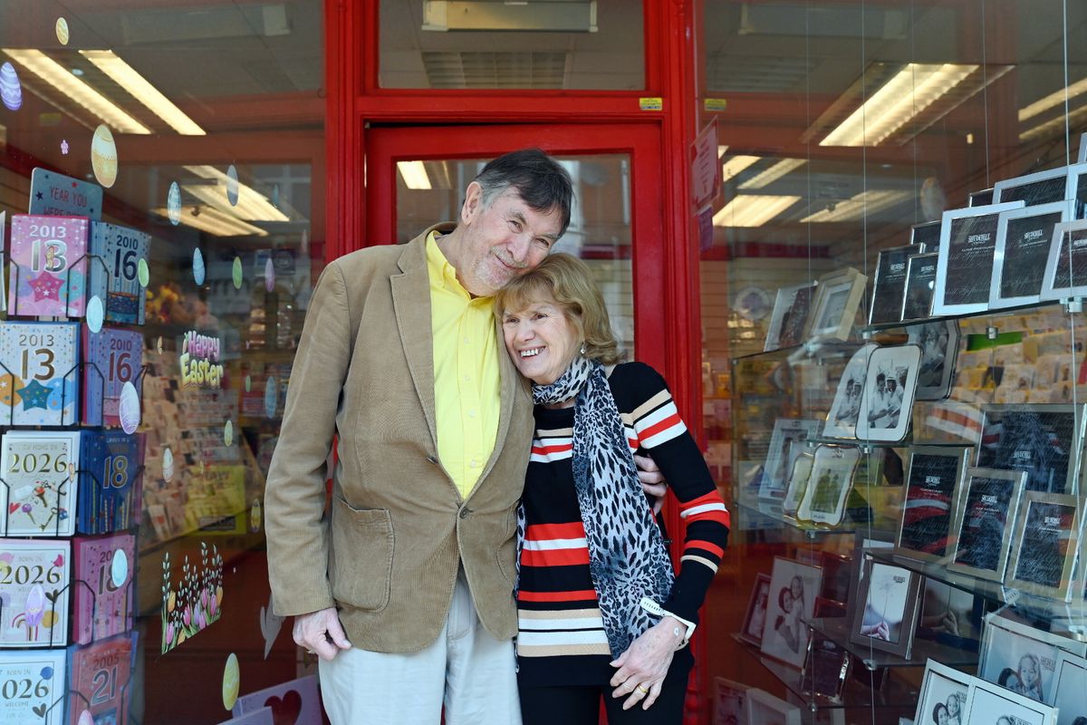 The pair are pictured outside the shop. Margaret has red hair and David has greying dark hair