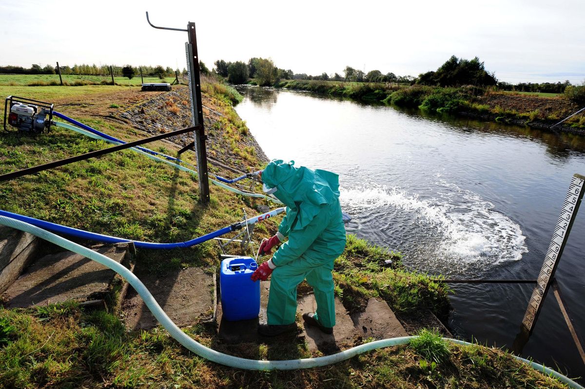File picture of an Environment Agency worker treating a river