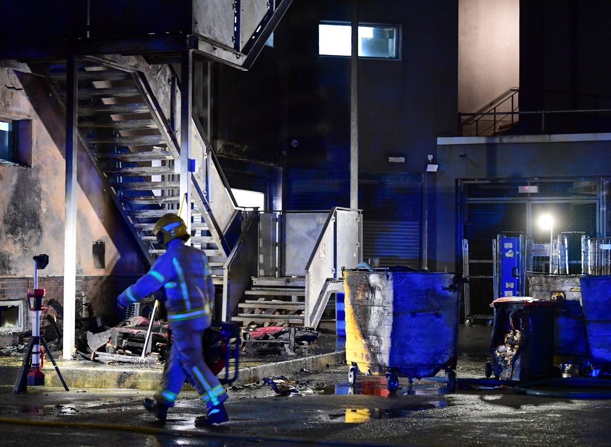 Firefighters assess the damage behind the hotel