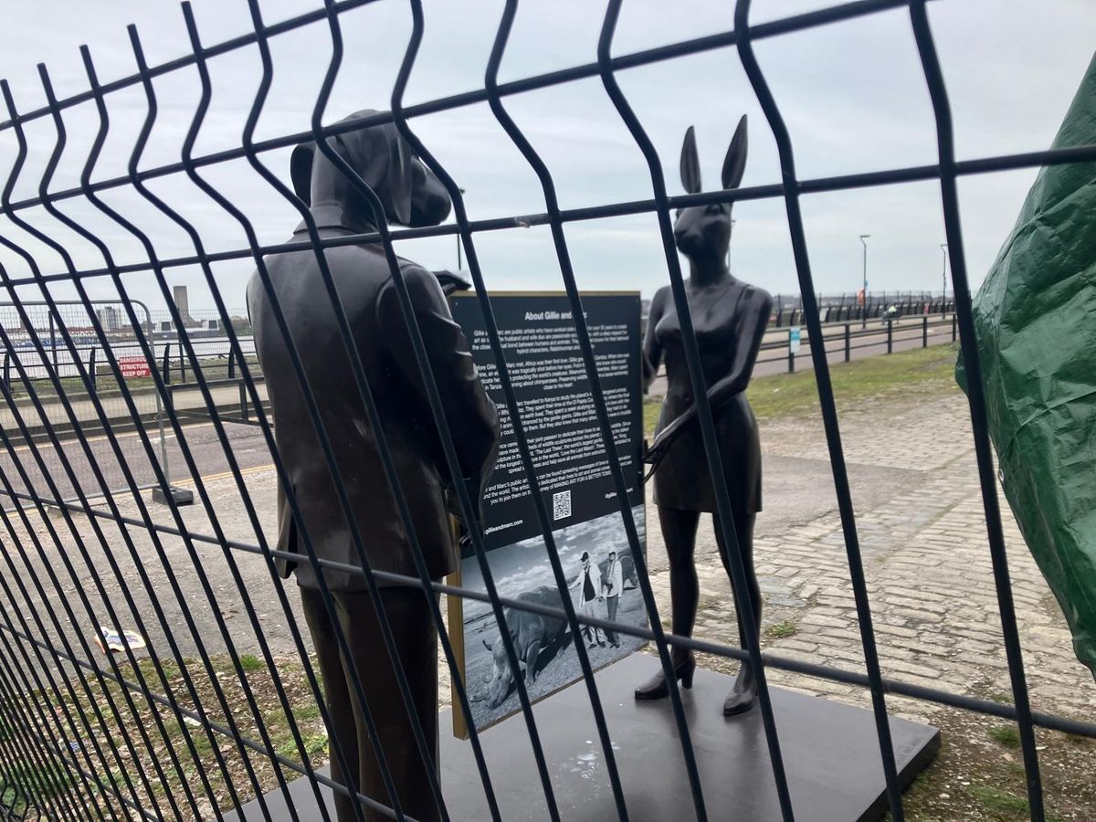 A man in a suit with the face of a dog and a woman in business wear with the face of a rabbit