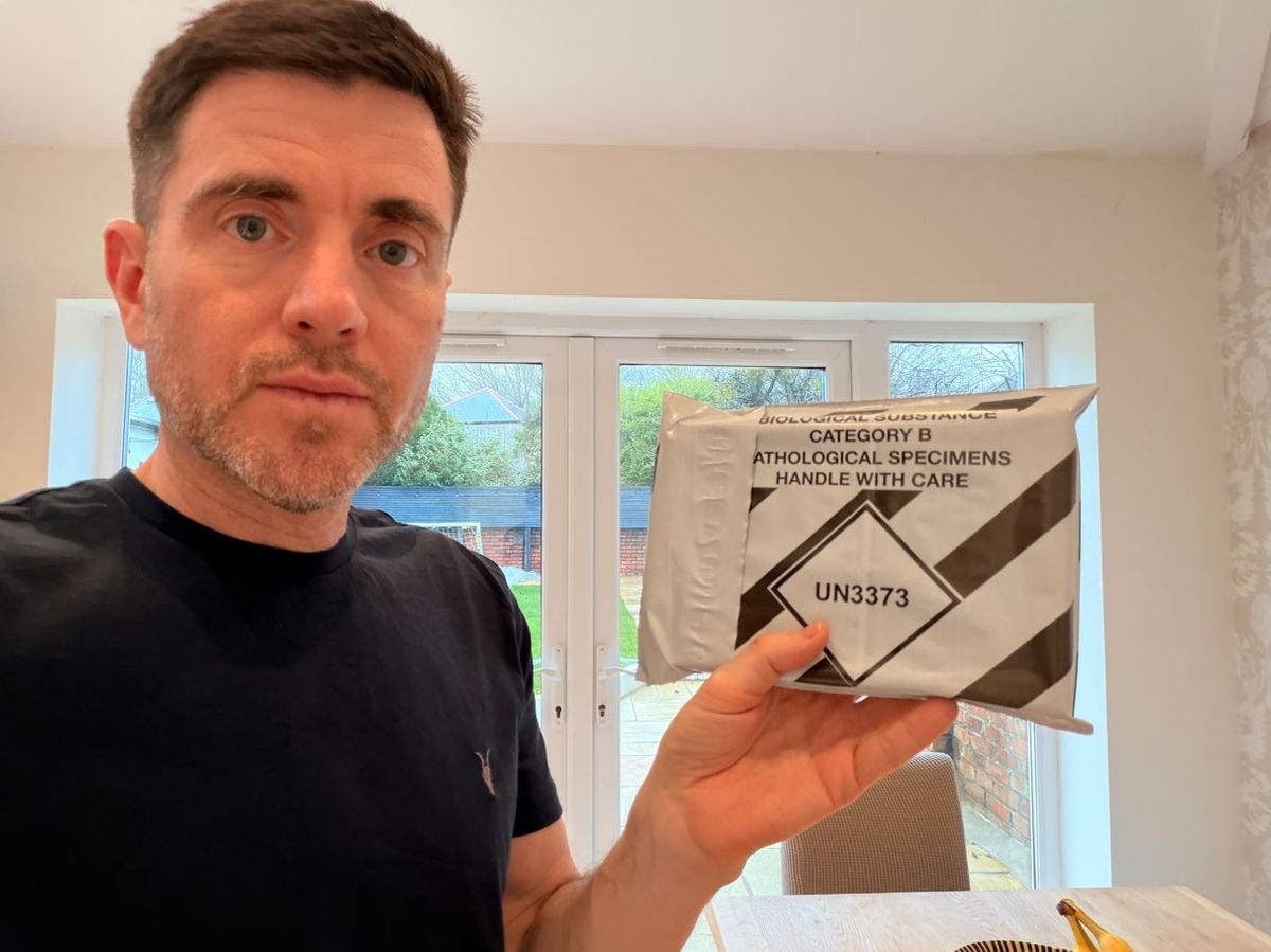 Steffan holds up the packaged health test ready for posting