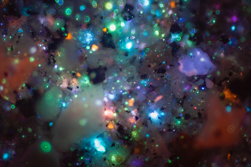 A vibrant, nebula-like expanse of swirling deep blues, violets, and glowing orange embers.