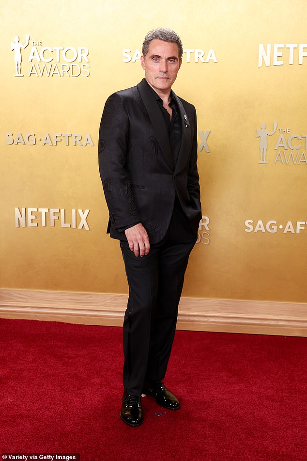 Rufus cut a dapper figure in an all black suit as he posed for the camera