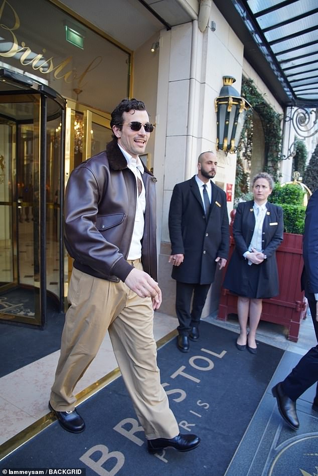 He looked suave in a brown leather aviator jacket, beige chinos and dress shoes