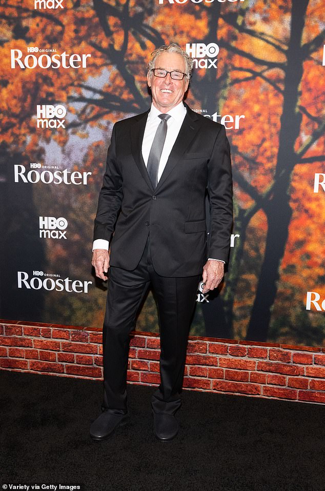 Scrubs star John C McGinley showed off an infectious smile while wearing a black suit and gray tie, as well as oddly casual black loafers