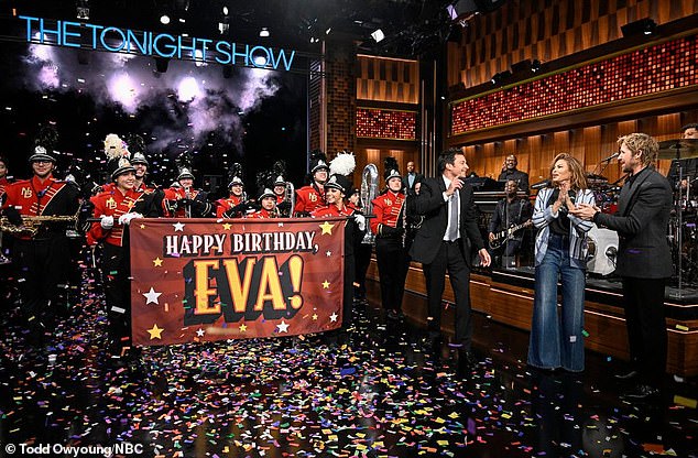 The pair were later seen standing next to a large sign that read 'Happy Birthday Eva!' which was held by a marching band