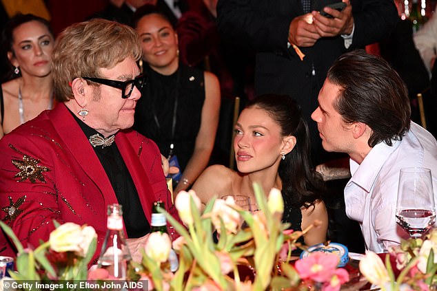 Elton John looked to be playing mediator between his godson Brooklyn Beckham and the hot-sauce influencer's superstar family at an Oscars viewing party on Sunday