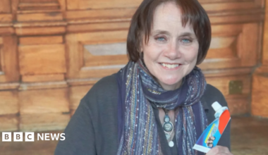 Councillor Zoe Cookson, pictured with short brown hair holds up a used toothpaste tube.
