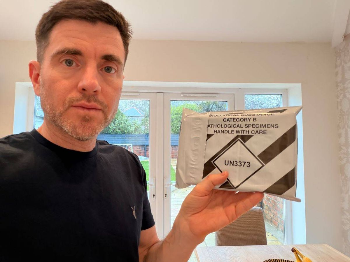 Steffan holds up the packaged health test ready for posting