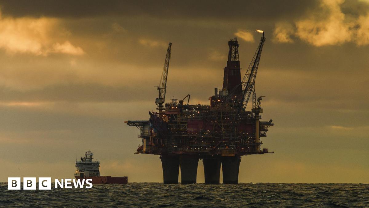 An oil rig in the North Sea on a cloudy day in the evening with a ship to the left of it.