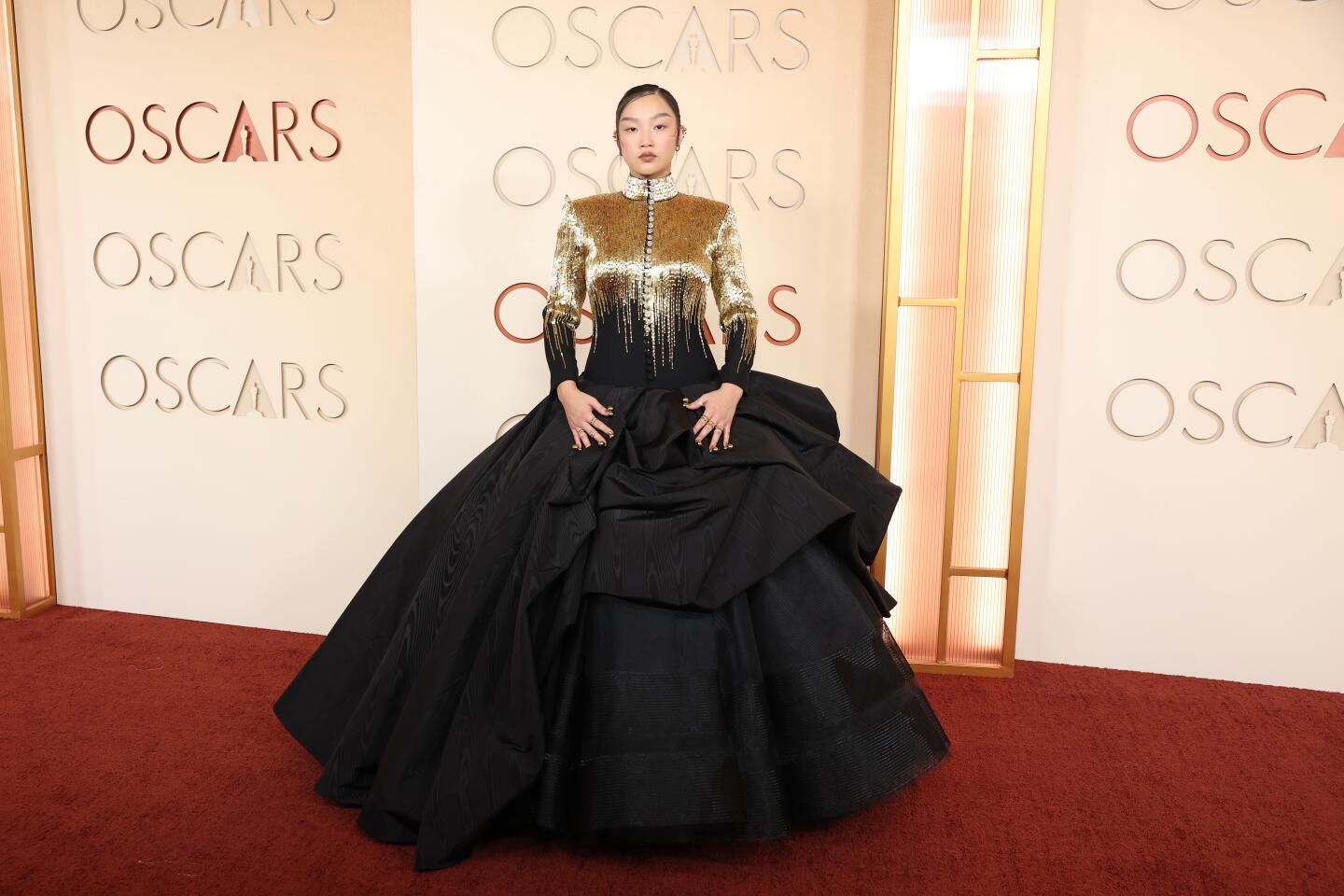 Audrey Nuna in a ball gown with gold on the top and black ruffles on the bottom half