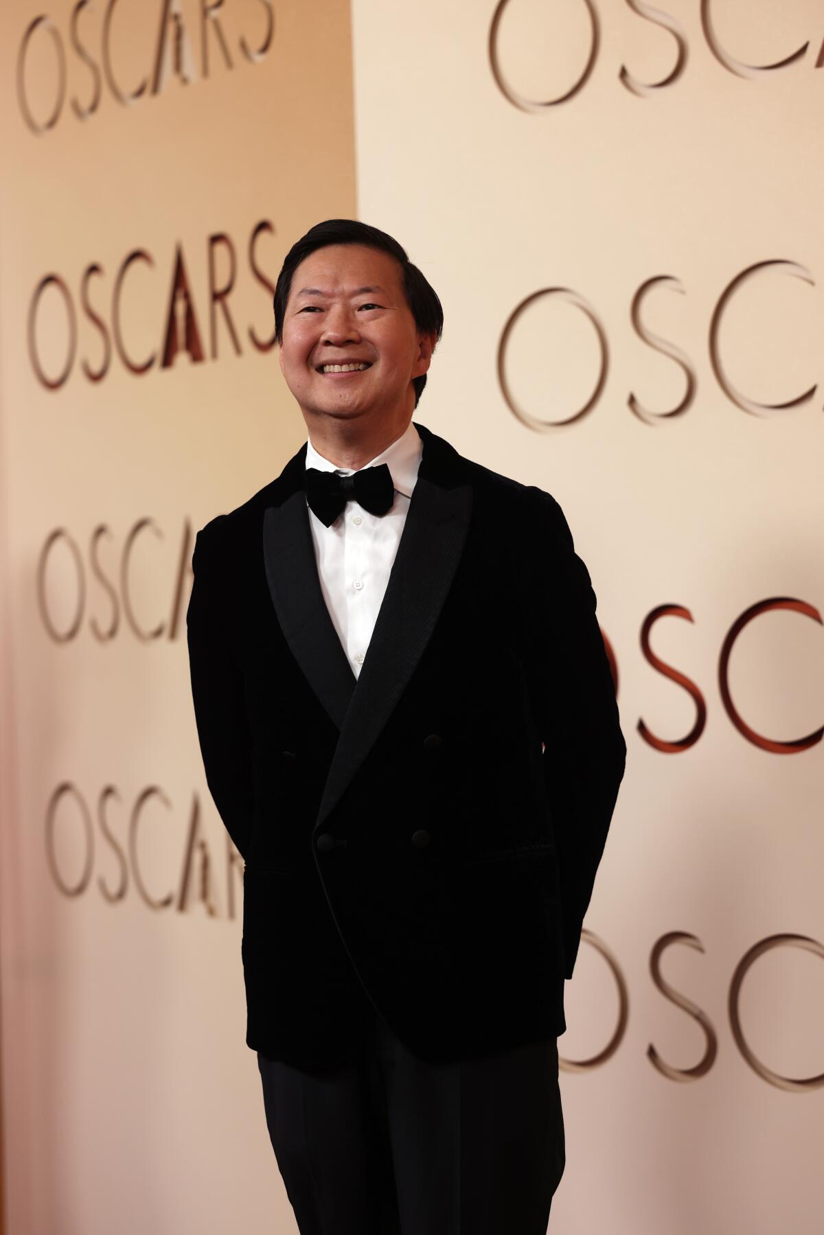 Ken Jeong wears a tux and smiles on the red carpet 