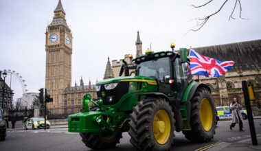 Farmers gathered in protest holding banners and signs, advocating for agricultural rights and policy reforms in rural sett...