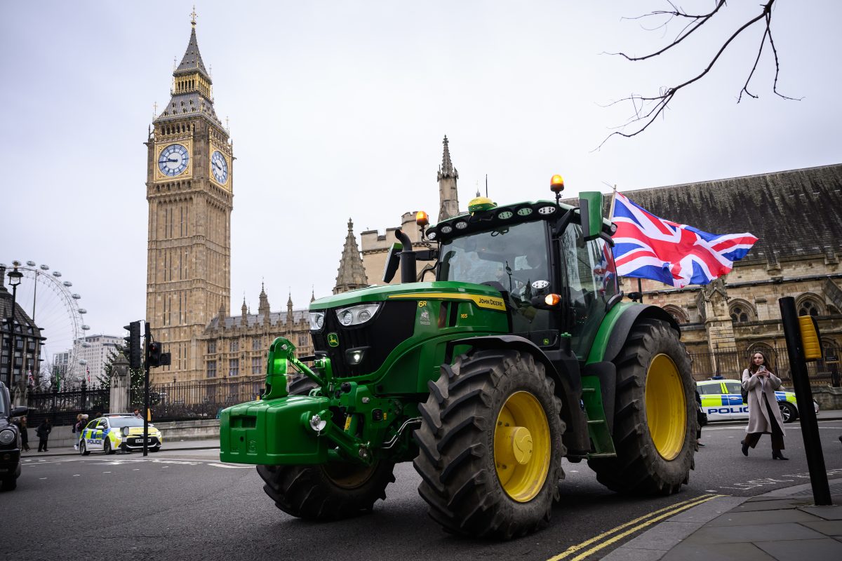 Farmers gathered in protest holding banners and signs, advocating for agricultural rights and policy reforms in rural sett...