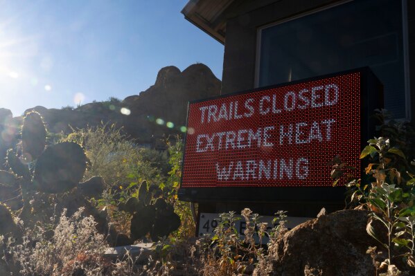 A sign warns hikers of trail closures due to extreme heat at Camelback Mountain on Thursday, March 19, 2026, in Phoenix. (AP Photo/Rebecca Noble)