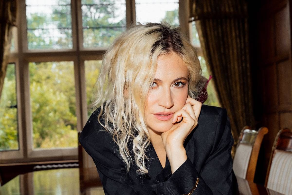 Pixie Lott in black sat at table