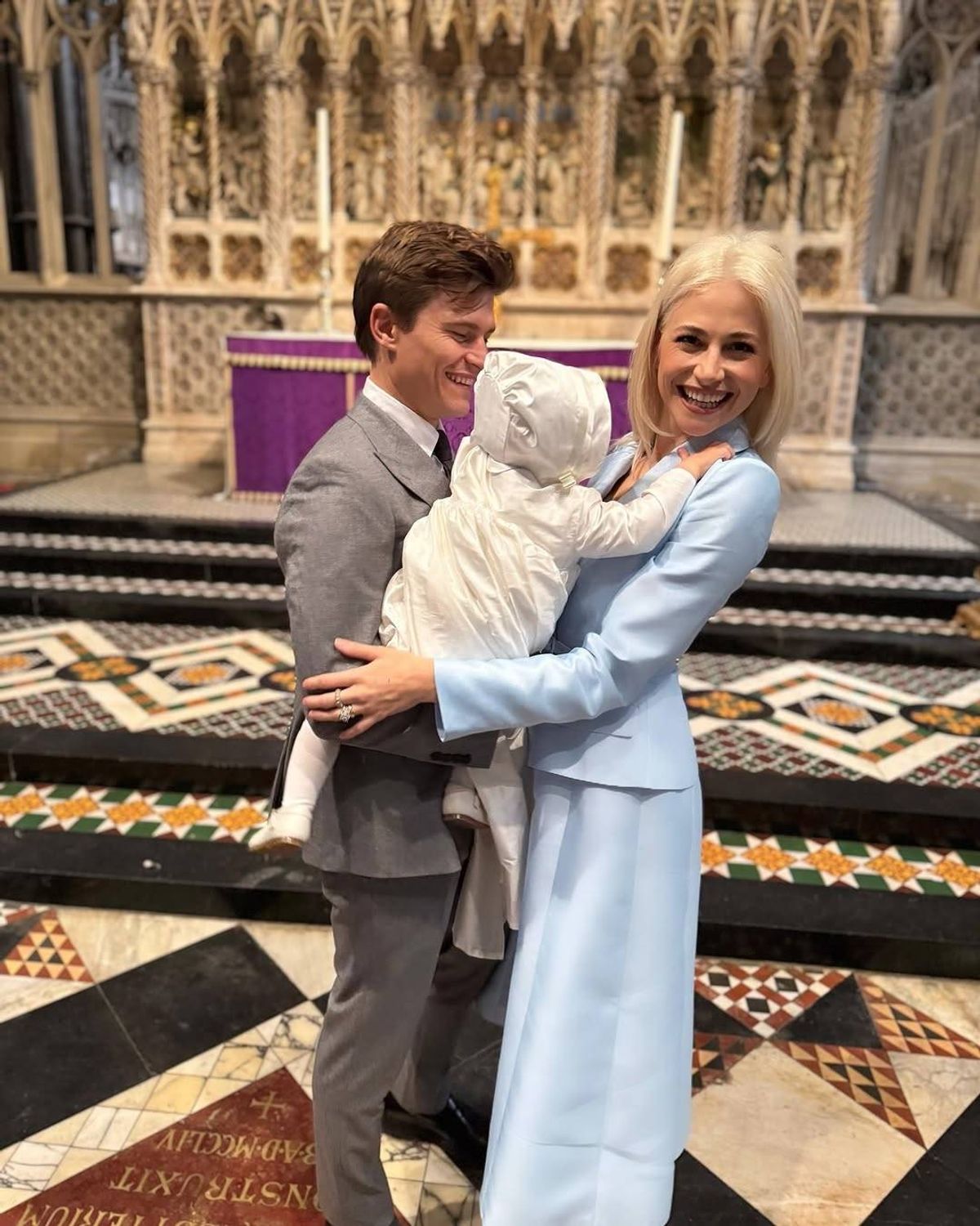 pixie lott and husband holding baby in church at his christening