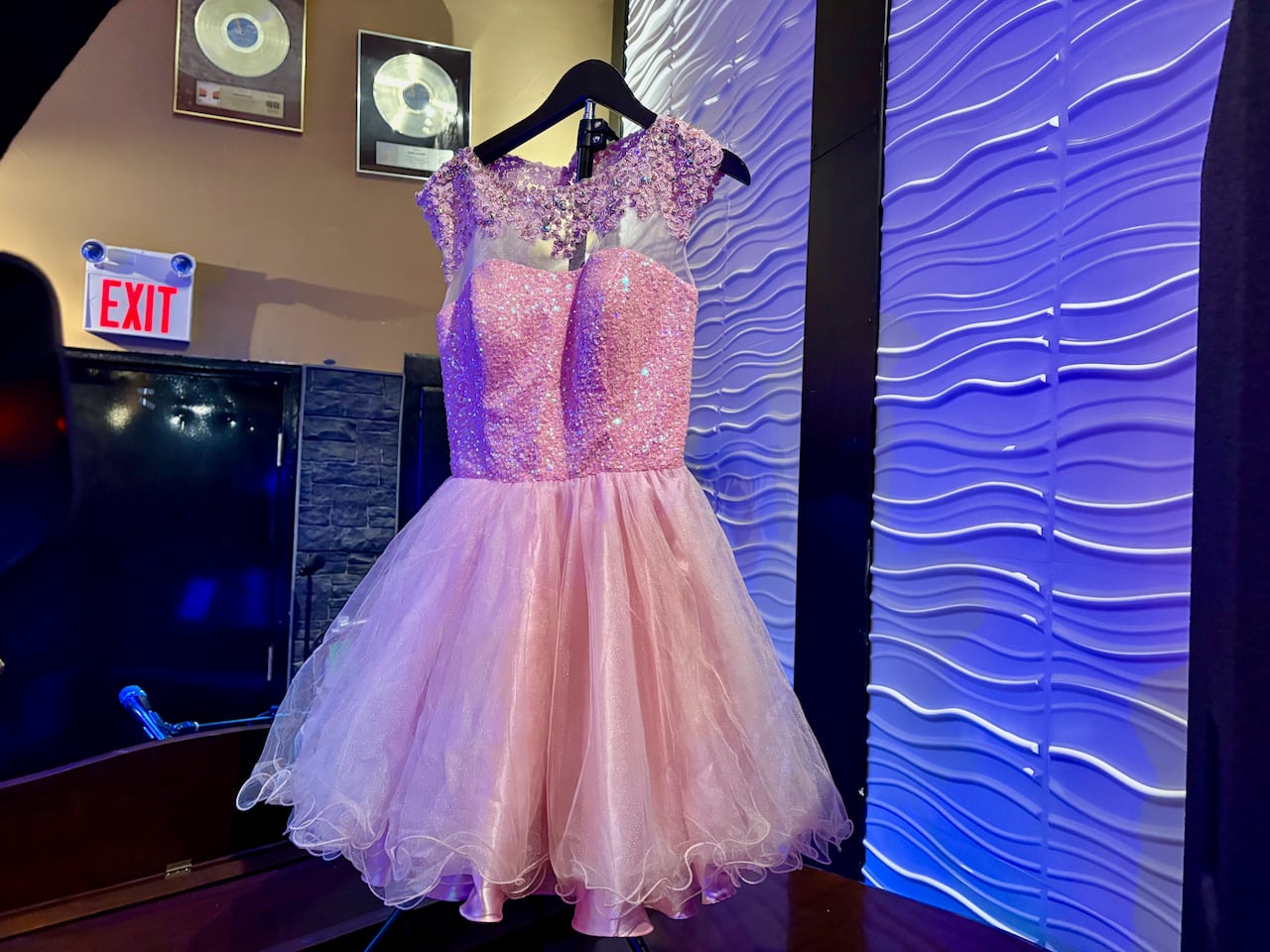 A pink dress hangs on a hanger.