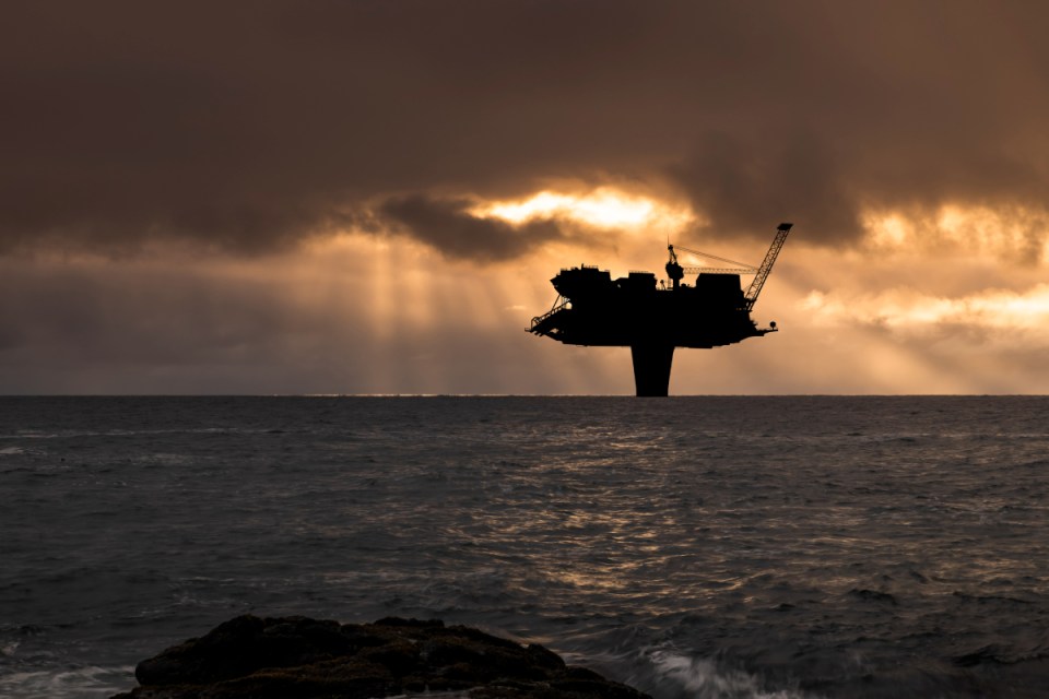 North Sea oil terminal with storage tanks and docking facilities under a clear sky, highlighting energy infrastructure.