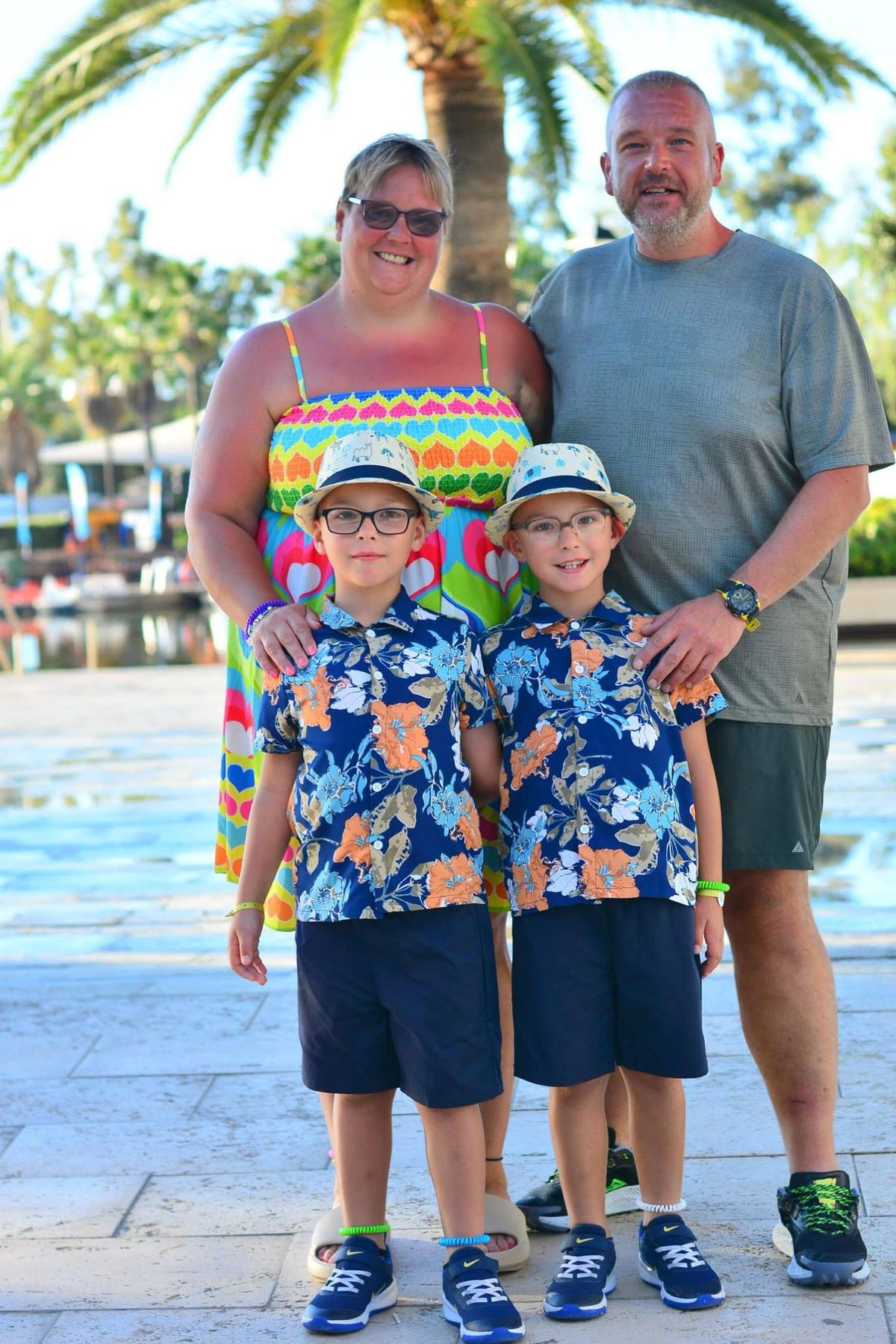 Smiling parents on holiday with their young twin sons