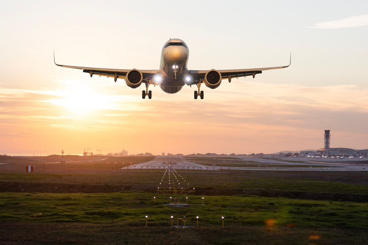 Passenger airplane taking off at sunset