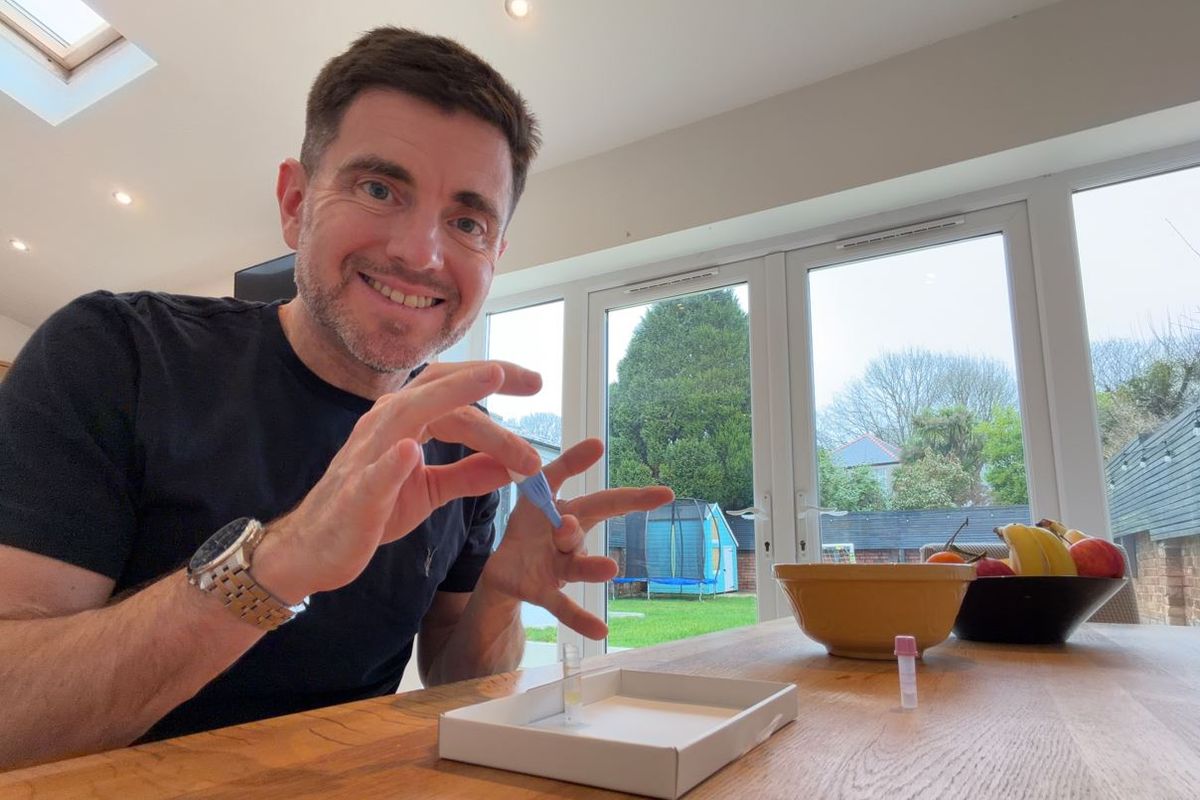 Steffan Rhys smiles for the camera as he holds a lance to his finger preparing to take a blood test