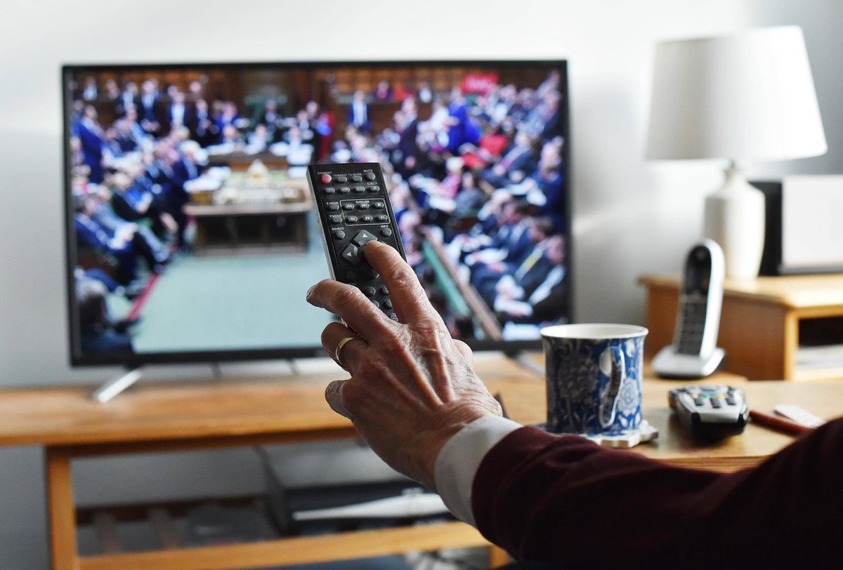 A person using a remote control while watching TV