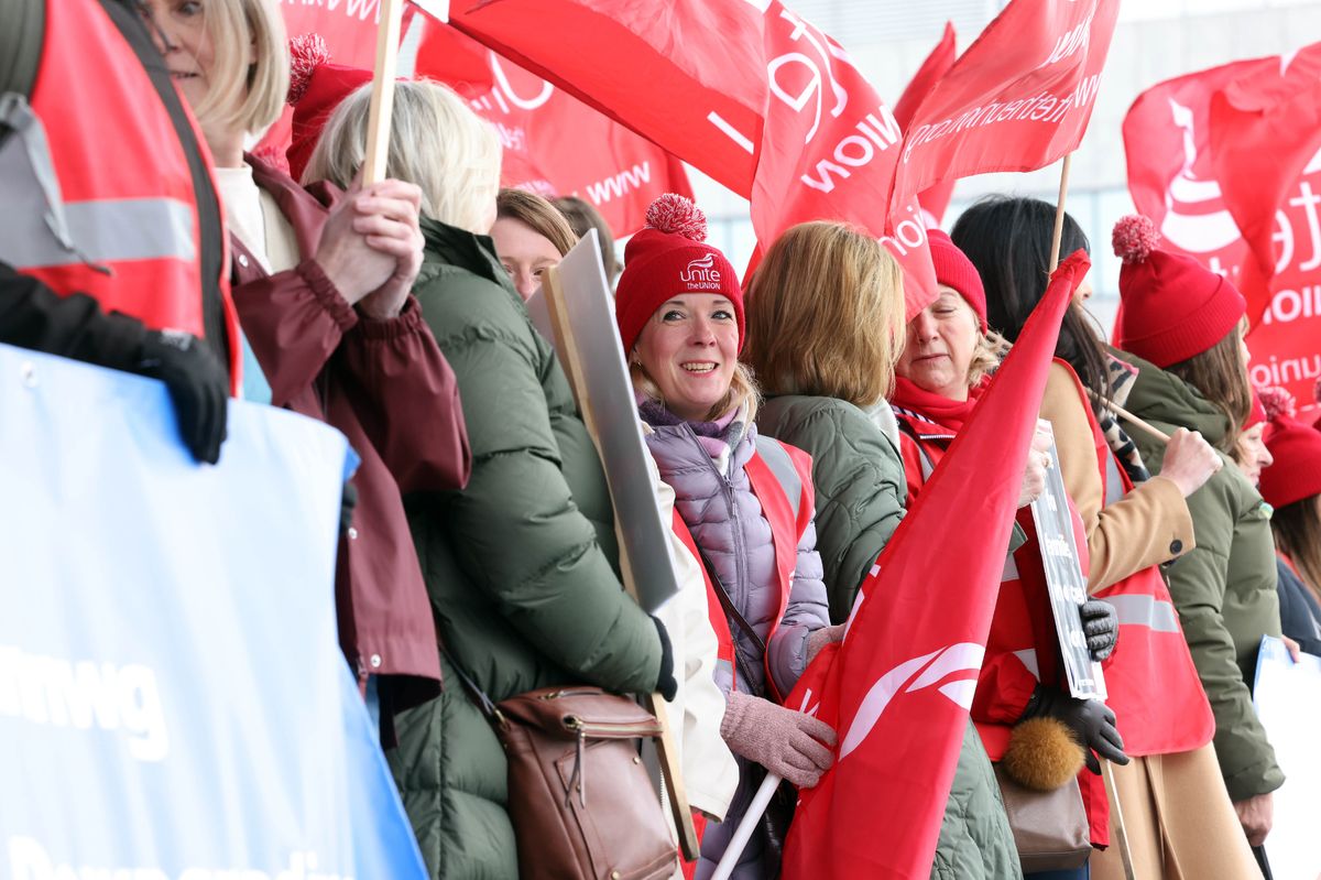 Workers at Cwm Taf Morgannwg University Health Board, supporters and representatives gather on the steps of the Senedd with flags and hats