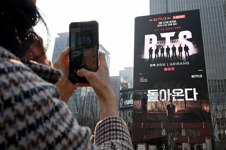 A fan records a promotional video for BTS' comeback on an electronic billboard near Gwanghwamun Square in Jongno District, central Seoul, Tuesday, four days ahead of the supergroup's scheduled performance. Korea Times photo by Park Ji-yeon