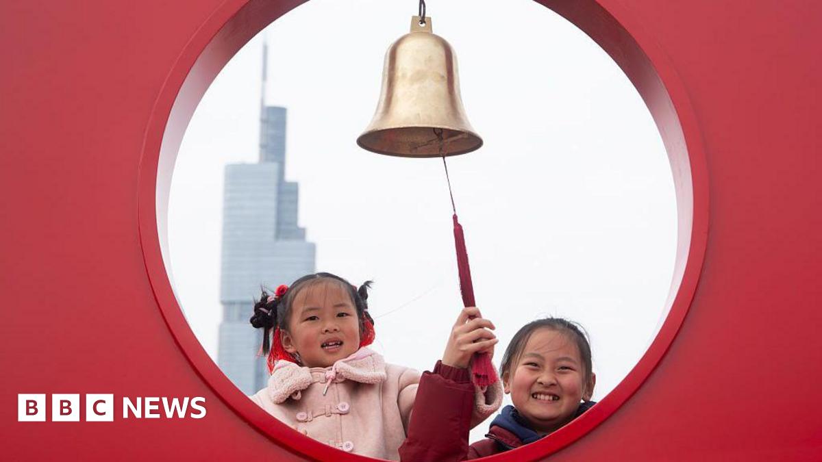 Two young girls ring the New Year bell on the city wall of Nanjing on the first day of the Chinese Lunar New Year in Nanjing, China, on February 17, 2026.