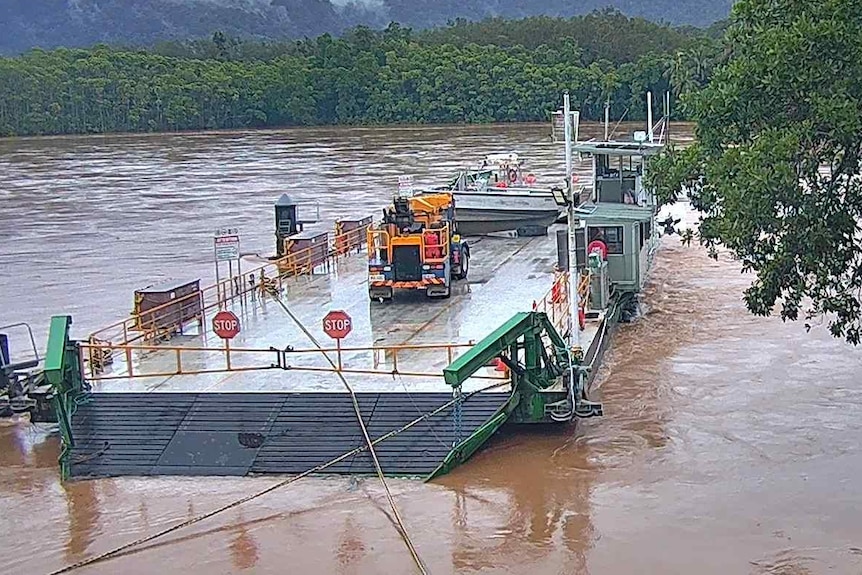 Barge sits still on very flooded river around rainforests