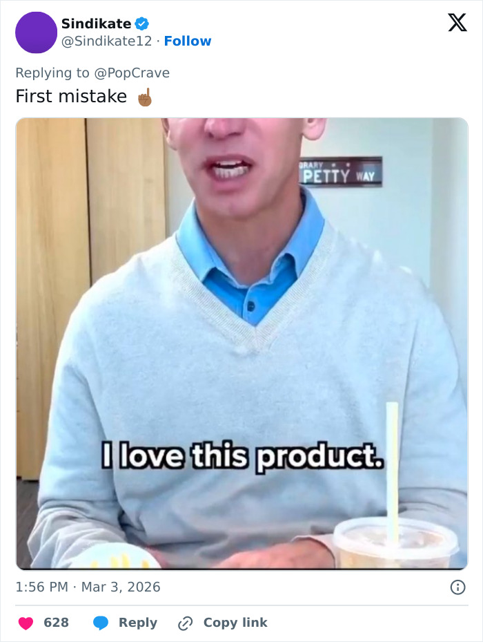 Burger King boss wearing blue shirt and gray sweater enjoying a Whopper with a drink visible on the table. Burger King boss wearing blue shirt and gray sweater enjoying a Whopper with a drink visible on the table.