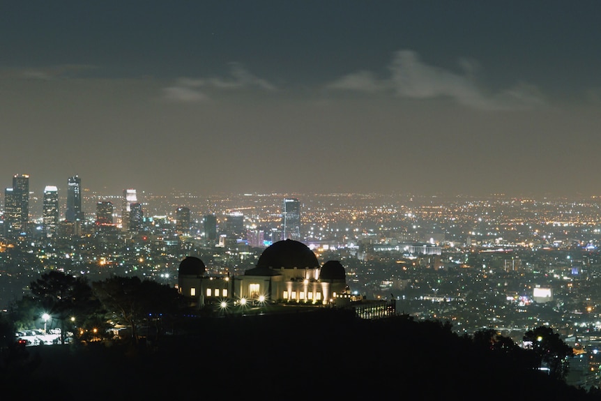 Lights from the observatory and city against a night sky with little stars