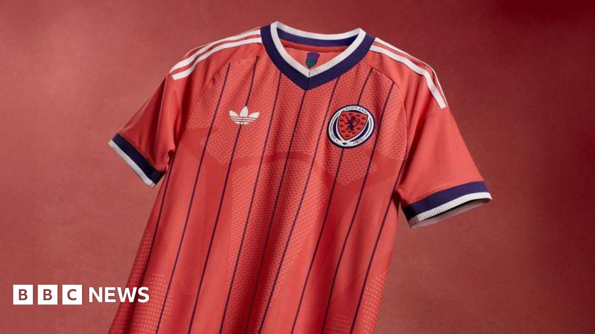 Salmon-pink Scotland shirt with dark purple pinstripes and white Adidas stripes down the shoulders and sleeves.