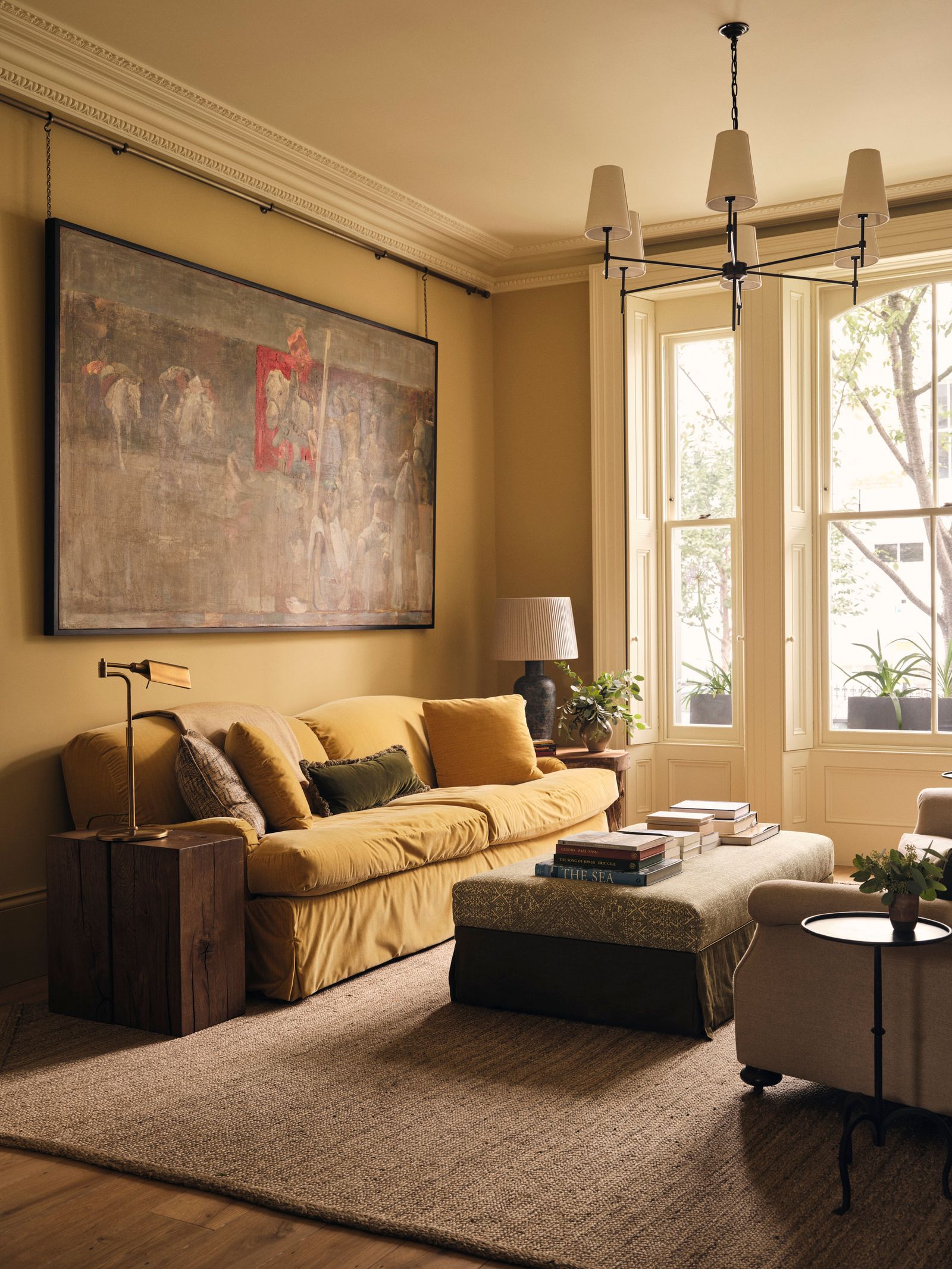 Image may contain Home Decor Lamp Plant Couch Furniture Art Painting Rug Book Publication and Indoors