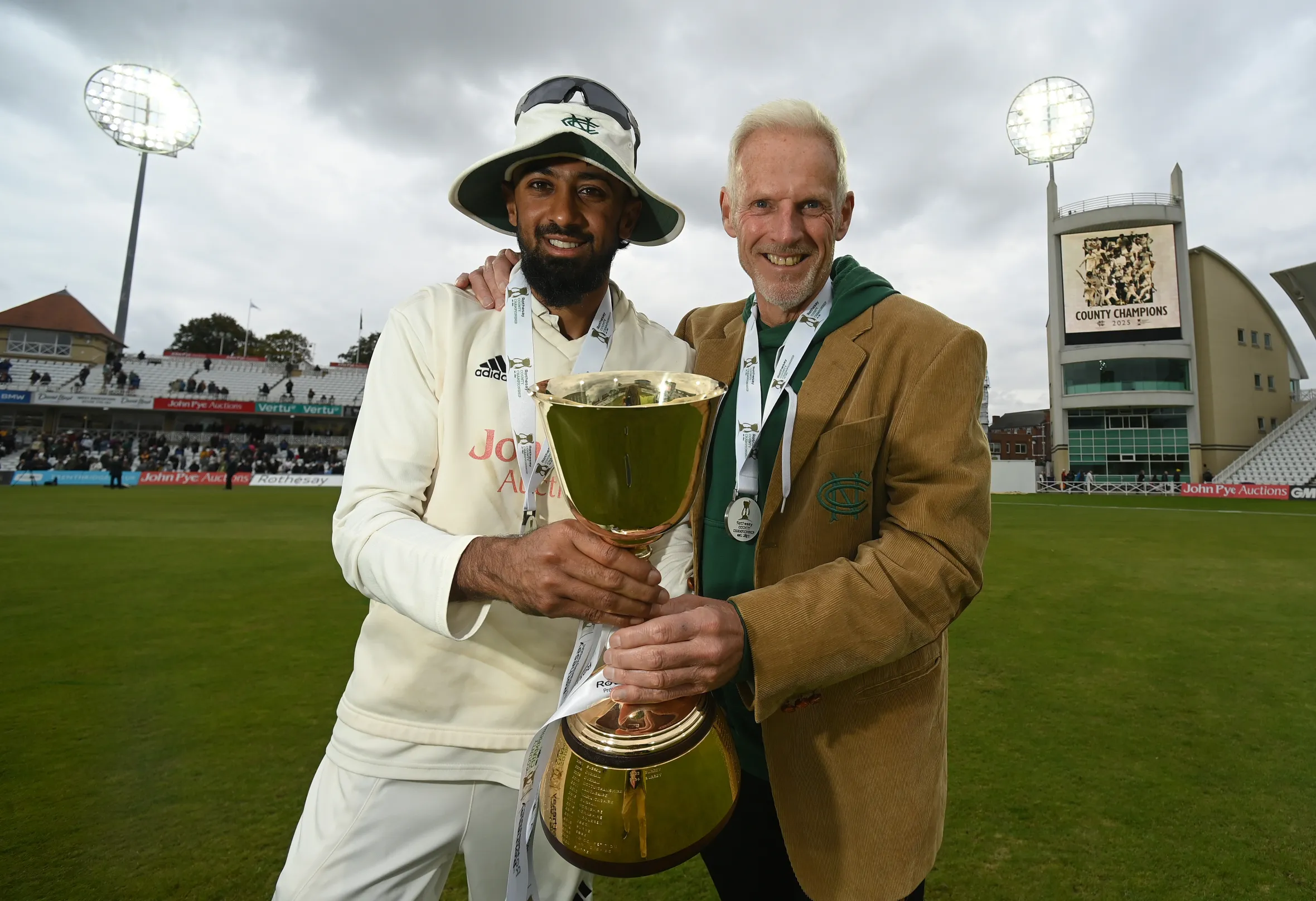 Nottinghamshire captain Haseeb Hameed and coach Peter Moores holding the County Championship Trophy at Trent Bridge.
