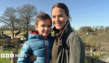 Freddie and his mum, Lauren, stand in the sunshine in fields near their home in Huddersfield